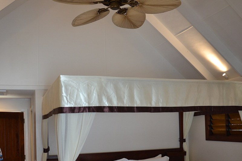 Interior of a traditional coastal village guest room with draped mosquito netting